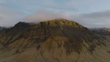 Aerial-landscape-view-of-typical-icelandic-mountain-peaks,-on-a-cloudy-evening