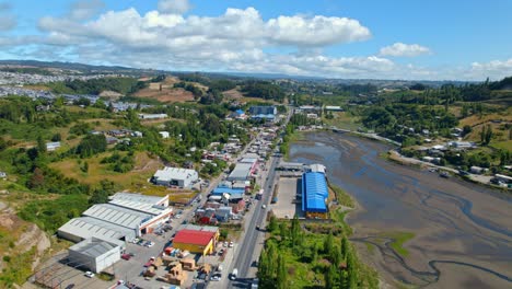 View-from-above-establishing-de-Castro,-Chiloé-natural-green-in-the-city-with-a-cloudy-but-sunny-horizon-in-Chile