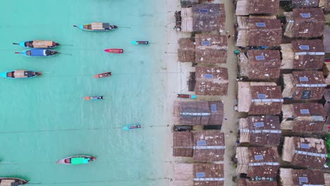 Aerial-Drone-Top-Down-View-Over-a-Wooden-Hut-Village-with-Long-Tail-Boats-Along-the-Beach-in-Thailand