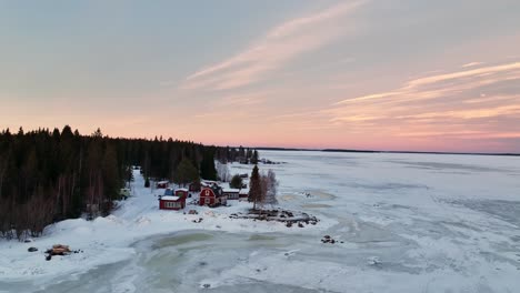 Dämmerung-über-Der-Schneebedeckten-Bottenwiek-Mit-Roten-Häusern,-Luleå,-Schweden,-Luftaufnahme