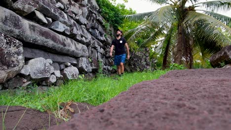 Tourist-visiting-the-ancient-cit-of-Nan-Madol-and-walking-around-the-big-stone-outer-walls-of-ruins