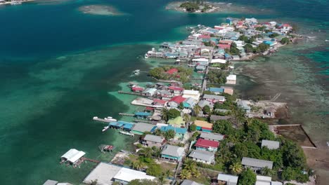 Aerial-establishing-overview-of-fishing-village-and-docks-built-around-reef-flats-in-Utila-Honduras