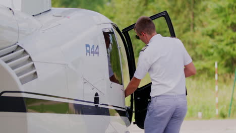 Pilot-Besteigt-Einen-Weißen-Robinson-R44-Hubschrauber