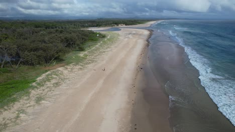 Flying-Over-Sandy-Beach,-Belongil-Beach-And-Creek-In-NSW,-Australia---Drone-Shot