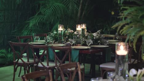 Elegante-Diseño-De-Mesa-De-Banquete-En-Una-Boda,-Con-Cristalería,-Platos,-Centros-De-Mesa-Con-Helechos-Y-Flores