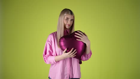 Liebevolle-Frau-Hält-Und-Umarmt-Einen-Roten-Herzballon,-Isolierter-Gelber-Hintergrund