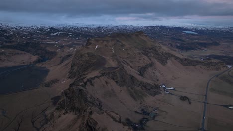 Aerial-panoramic-landscape-view-over-icelandic-mountain-peaks,-with-a-dramatic-evening-cloudscape