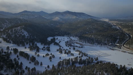 Eislaufen-Schlittschuhlaufen-Eishockeybahn-See-Teich-Eishockey-Winter-Etown-Evergreen-Lake-House-Angelzelte-Denver-Golfplatz-Colorado-Luftaufnahmen-Filmdrohne-Sonnenuntergang-Goldene-Stunde-Winter-Neuschnee-Rückwärtsbewegung