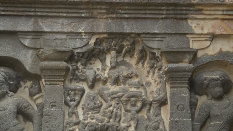 Closeup-of-rock-cut-sculptures-of-god-and-goddess,-painted-artwork-of-Ellora-Caves,-Maharashtra,-India