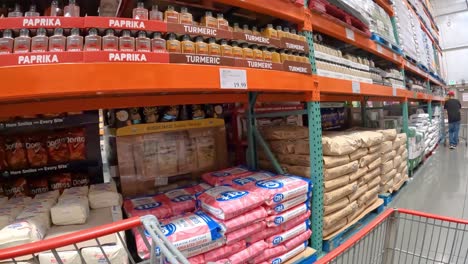 POV---Slowly-pushing-the-grocery-cart-past-a-variety-of-baking-needs-including-flour,-sugar-and-spices-at-local-Costco