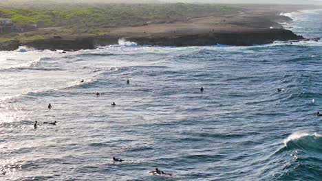 Los-Surfistas-Esperan-En-Fila-Sentados-A-Bordo-Mientras-Grandes-Olas-Ruedan-En-Conjuntos.