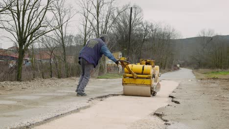 Middle-age-worker-male-Hand-Operated-Mini-Road-Roller-Compactor-gravel