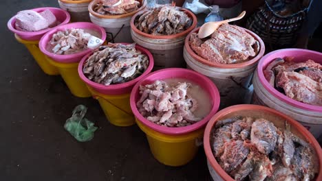 In-the-market-in-Laos,-there-is-a-display-of-various-types-of-preserved-fish-neatly-arranged-inside-a-bucket