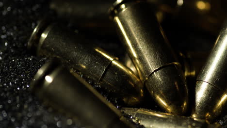 9×19mm-Parabellum-bullets-sitting-on-gunpowder-dust-pile,-macro-detail-closeup