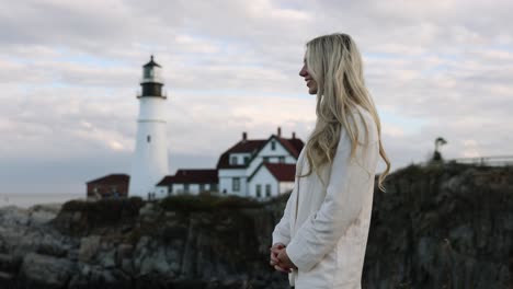 Beautiful-Blonde-Model-Smiling,-Lighthouse-In-Background