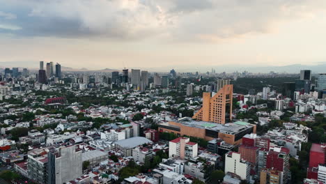 Aerial-view-rising-over-the-cityscape-of-Polanco,-hazy-evening-in-Mexico-city