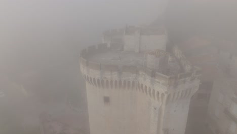 Aerial-view-through-foggy-weather-on-Tour-Philippe-le-Bel-,-a-medieval-tower-in-Villeneuve-lès-Avignon,-France