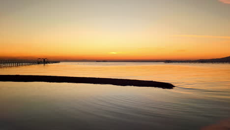 Un-Muelle-En-Aguas-Tranquilas-Durante-Un-Amanecer-Dorado