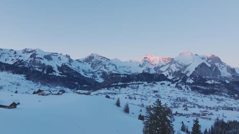 Imágenes-Capturadas-Por-Drones-Que-Muestran-La-Encantadora-Belleza-Del-Amanecer-Que-Proyecta-Un-Tono-Dorado-En-La-Silueta-De-Una-Cadena-Montañosa-Cubierta-De-Nieve.