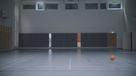 Statische-Ansicht-Eines-Basketballs,-Der-In-Einer-Leeren-Turnhalle-Rollt