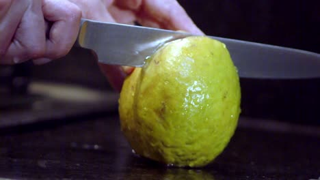 Carefully-slicing-vertically-down-the-center-of-the-Guava-fruit