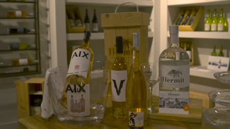 Bottles-of-alcohol-presented-on-wooden-table-in-wine-cellar,-Aix-Rose,-Hermit-Gin