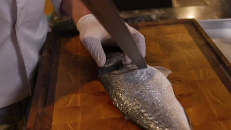 Chef-Skilfully-Slicing-Fresh-Fish-On-Cutting-Board