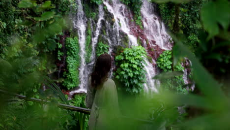 Female-traveler-discovers-scenic-Banyu-Wana-Amertha-falls-in-Bali-jungle,-slomo