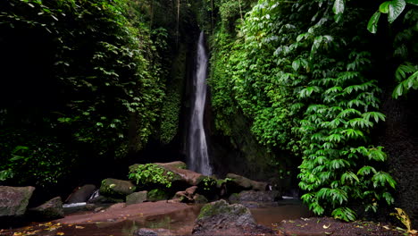 Zeitlupe-Des-Hohen,-Schmalen-Leke-Leke-Wasserfalls,-Umgeben-Von-Klippen-Und-Vegetation