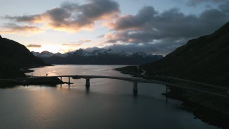 Puente-Sobre-Sundklakkstraumen-En-Noruega-Durante-El-Crepúsculo,-Montañas-En-El-Fondo,-Cielo-Sereno-Al-Atardecer