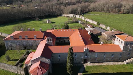 Orange-roof-and-fine-masonry-walls-of-San-Salvador-de-Ferreira-monastery,-drone