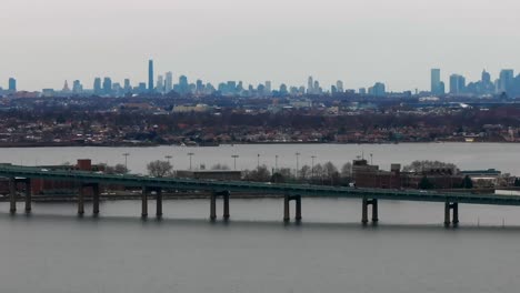 An-aerial-view-of-the-Throgs-Neck-Bridge-elevated-roadway-from-over-the-Long-Island-Sound,-NY-on-a-cloudy-day