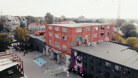 Aerial-orbit-shot-over-the-Telliskivi-Loomelinnak-Cultural-Center-with-Artistic-Murals