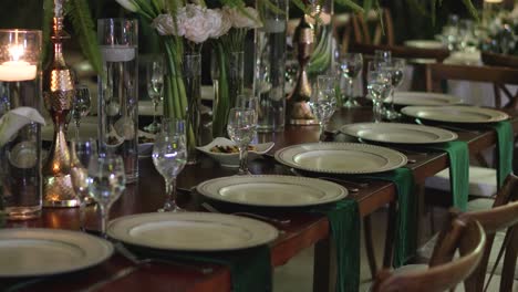 Elegante-Banketttischgestaltung-Bei-Einem-Hochzeitsempfang-Mit-Gläsern,-Tellern-Und-Natürlichen-Blumen