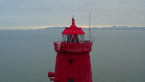 Roter-Achteckiger-Poolbeg-Leuchtturm-Bei-Sonnenuntergang,-Rückwärtsfahrt-über-Die-Luft
