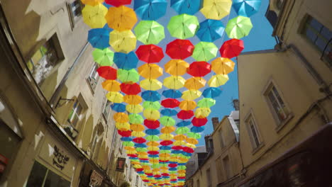 Conducir-Bajo-Sombrillas-Multicolores-Colgando-En-La-Calle-De-La-Pequeña-Ciudad