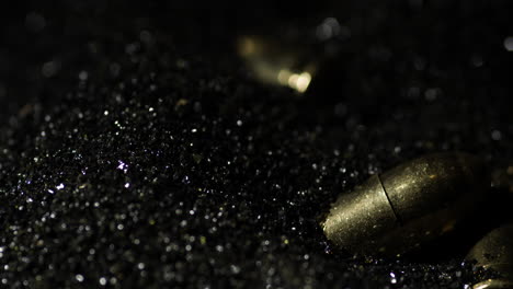 9×19mm-Parabellum-bullets-macro-detail-closeup-shot-fall-on-gunpowder,-slowmo