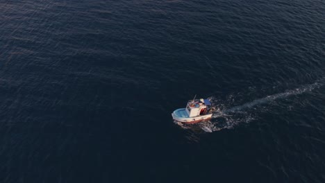 Aerial-view-of-fishing-boat-on-Mediterranean-Sea-at-sunset,-Sicily,-Italy