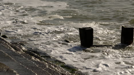 Plano-Medio-De-Olas-Rompiendo-Contra-Espigones-Y-Defensas-Marítimas-En-Milford-On-Sea