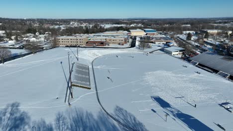 Aerial-shot-of-a-high-school-sports-field-covered-in-snow