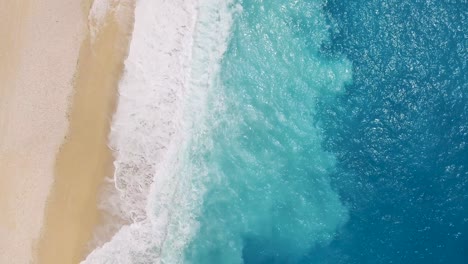 Myrtos-Strand-Mit-Einer-Einzelnen-Person,-Die-Im-Sand-Liegt,-Türkisfarbene-Wellen-Plätschern-Ans-Ufer,-Luftaufnahme