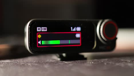 Nahaufnahme-Des-OLED-Bildschirms-Des-Drahtlosen-Mikrofonempfängers-Mit-Verschiedenen-Anzeigesymbolen-Wie-Lautstärke,-Batteriestand-Und-Frequenz