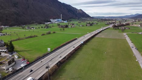 Verkehr-Auf-Der-Schweizer-Autobahn-Zwischen-Grünen-Feldern-Und-Alpenbergen