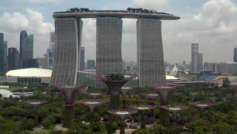 Jardines-Junto-A-La-Bahía-Con-El-Hotel-Marina-Bay-Sands-Desde-Una-Toma-Aérea-De-Un-Dron-Que-Revela-La-Ciudad-De-Singapur