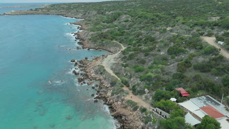 Eine-Luftaufnahme-Des-Konnos-Strandes-In-Ayia-Napa,-Zypern,-Zeigt-Eine-Abgeschiedene-Bucht-Mit-Goldenem-Sand,-Klarem-Blauen-Wasser-Und-Umgebendem-Grün,-Ein-Perfekter-Ort-Zum-Entspannen-Und-Schwimmen