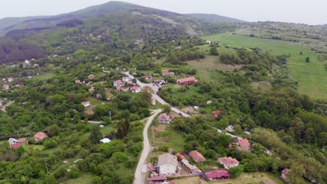 Orbiting-drone-shot-of-the-mountains-and-fields-of-Tsarichina-Hole-Village,-a-mysterious-place-in-a-Bulgarian-countryside