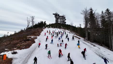 Esquiadores-Bajando-En-Una-Pendiente-Nevada-Cerca-De-La-Torre-Dolni-Morava-Sky-Walk