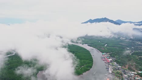 Volando-Por-Encima-De-Las-Nubes-Con-Un-Pueblo-De-Pescadores-Debajo-En-El-Río-Lang-Thung-Nang-Dam-En-La-Provincia-Del-Distrito-De-Khura-Buri,-Tailandia