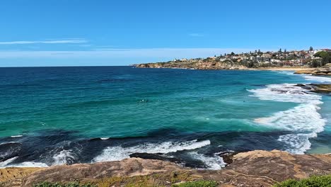 Coastal-view-of-Tamarama-beach,-Sydney-with-vibrant-blue-ocean,-waves-and-clear-sky