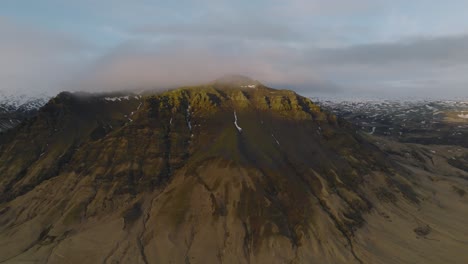 Aerial-panoramic-landscape-view-over-icelandic-mountain-peaks,-on-a-cloudy-evening
